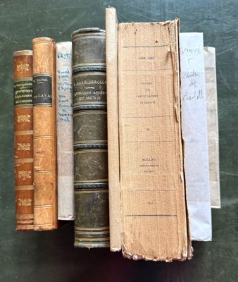 several old books are stacked on top of each other on a table