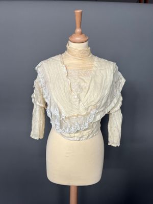 an image of a mannequin torso with a white blouse on it