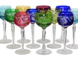 several different colored wine glasses are lined up in a row