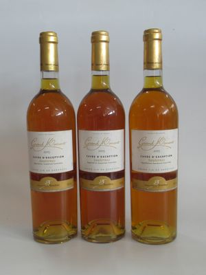 three bottles of wine sitting next to each other on a white surface