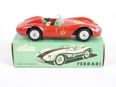 une petite voiture rouge posée sur une boîte verte