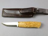 a knife and sheath on a table next to each other