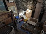 a pile of junk in a room with a stone wall