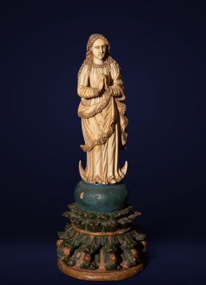 a carved ivory figurine of a woman holding a child