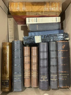 de nombreux livres anciens dans une boîte en carton posée sur l'étagère