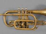 an old brass trumpet with two valves on a gray surface