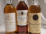 three bottles of wine are lined up on a white cloth