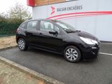 la petite voiture noire est garée devant un bâtiment