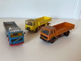 trois camions miniatures posés sur une table