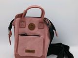 un sac à main rose avec une bandoulière noire et une paire de chaussures