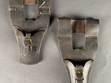 pair of old leather shoes with metal buckles on a gray surface