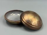 une vieille boîte en laiton contenant une loupe