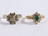 two gold rings with diamonds and a green stone