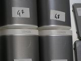 a stack of speakers sitting on a shelf next to a cell phone