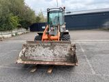 an image of a tractor with a bucket in a parking lot