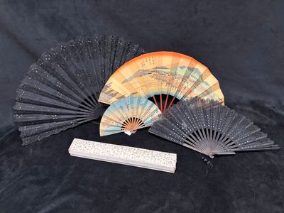 a small fan and a ruler sitting on a black surface