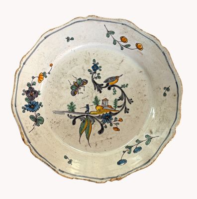 une assiette blanche décorée d'un oiseau et de fleurs