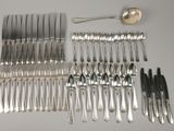 de nombreuses fourchettes et cuillères disposées sur la table