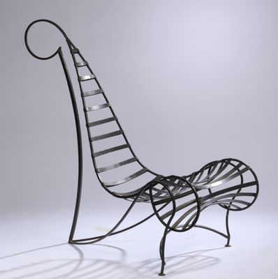 an iron bench with a curved back and a curved seat