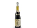 the bottle of wine is sitting on a white surface
