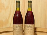 deux bouteilles de vin posées sur un tonneau en bois