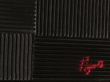 a red light on the side of a black wall