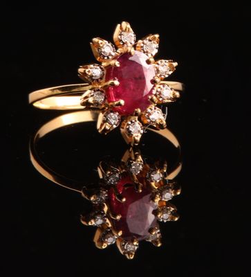 gros plan d'une bague en or avec un rubis et des diamants