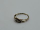 a gold ring with a diamond on top of it on a white surface