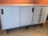 une armoire blanche à tiroirs et une chaise dans un coin