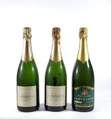 trois bouteilles de champagne posées les unes à côté des autres sur une surface blanche