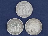 trois pièces d'argent sur lesquelles figurent l'effigie d'un homme et d'une femme
