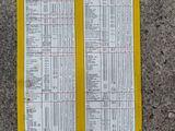 two yellow papers with numbers on them sitting on the ground