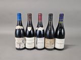 six bottles of wine are lined up in a row on a gray surface