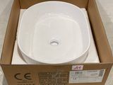 un évier blanc dans un carton posé par terre
