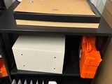 a black shelf with a heater and a white board on it