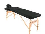 une table de massage noire sur laquelle est posé un coussin noir
