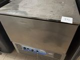 a stainless steel freezer sitting on a tiled floor
