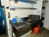 a kitchen with a sink, stove, and other items in it