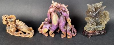 three figurines of different shapes and sizes on a black surface