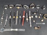 many different types of watches and bracelets laid out on a table