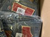 several pairs of blue jeans in a cardboard box with labels on them