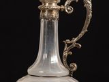a glass vase with a dragon handle on a table