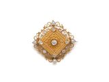 une image d'une broche en or et diamants sur fond blanc
