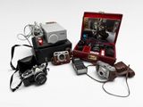 many different types of cameras sitting on a white surface