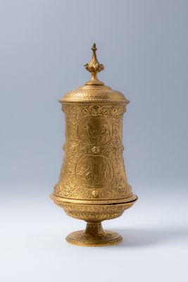 une urne plaquée or surmontée d'un oiseau