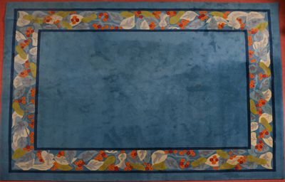 tapis bleu orné d'une bordure de fleurs et de feuilles