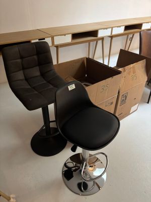 une chaise noire placée devant une table sur laquelle se trouve une boîte