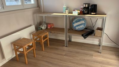 une petite table avec deux tabourets devant une fenêtre