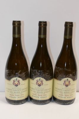 trois bouteilles de vin posées sur une table, l'une à côté de l'autre