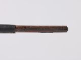 a wooden stick with a black handle on a white surface